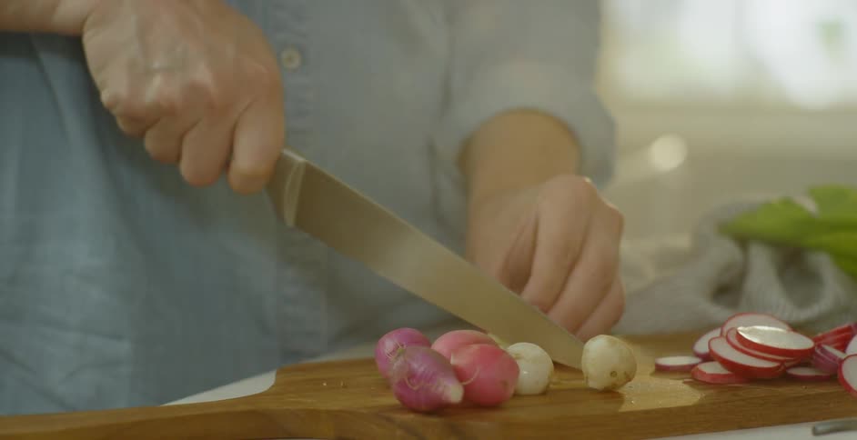A woman slices beets on a cutting board