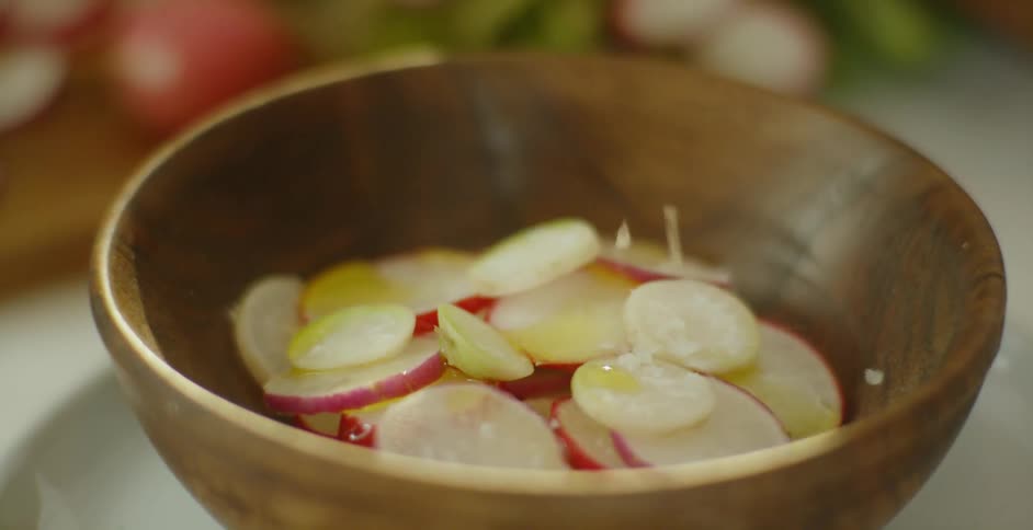 The pot of radish slices are being seasoned