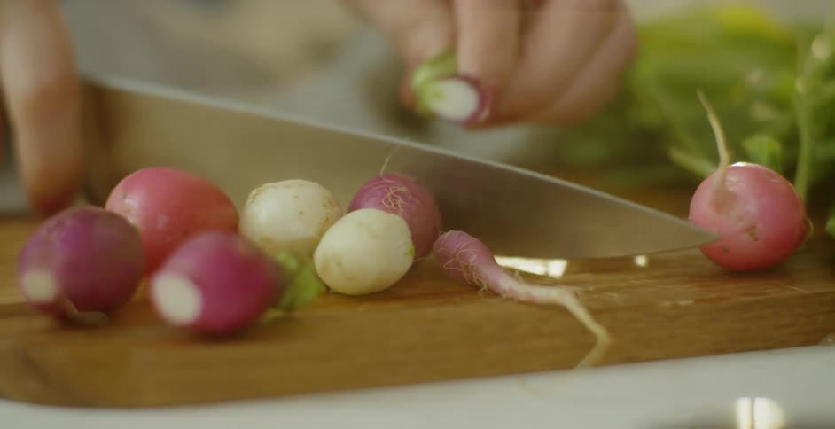 A woman slices beets on a cutting board