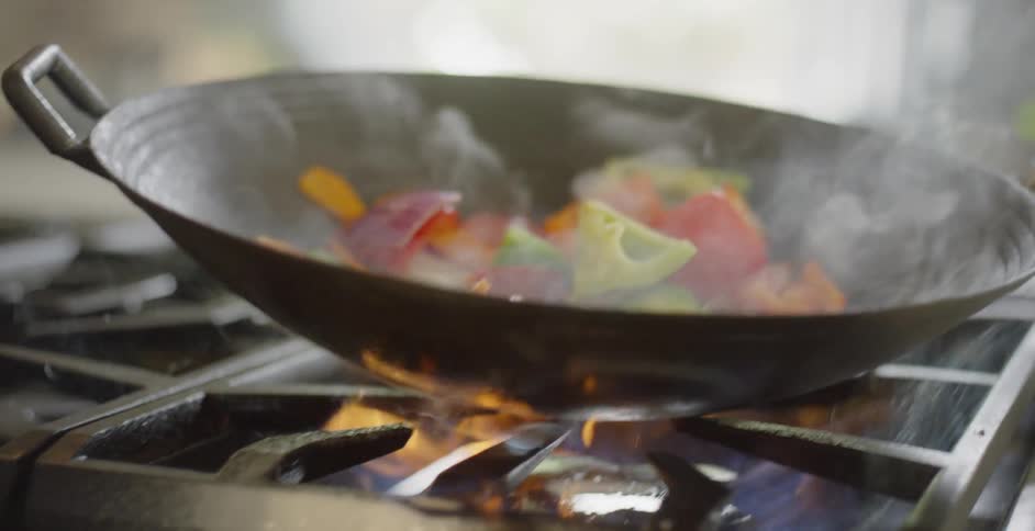 Vegetables are sauteed on a gas stovetop
