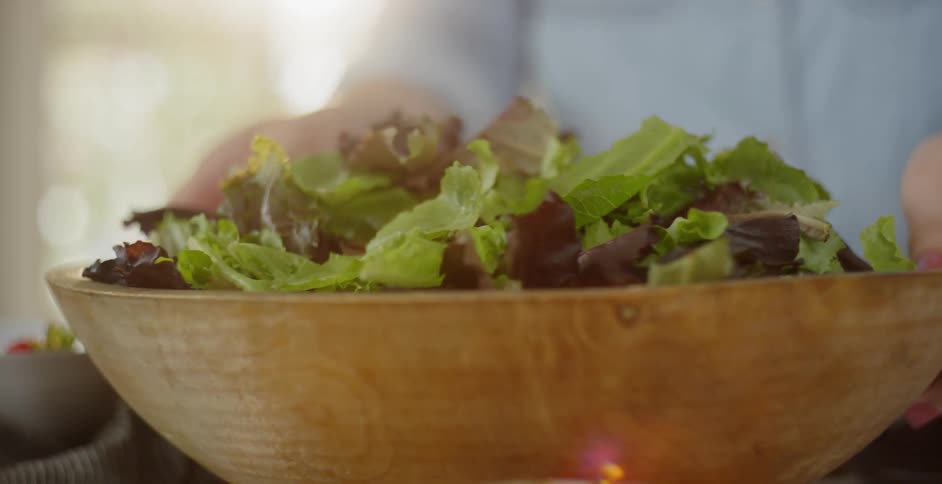 A woman spins a bowl of lettuce