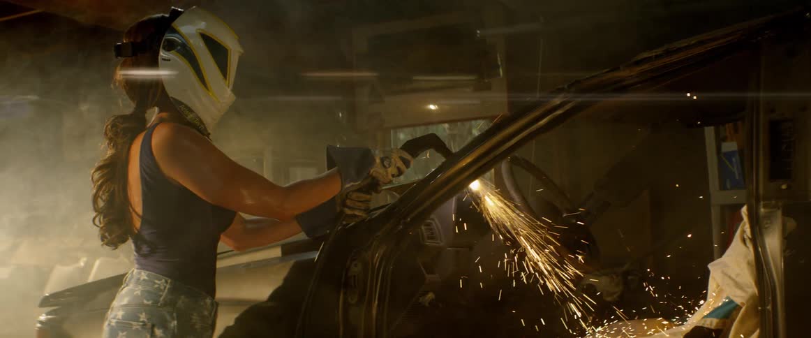 Woman welds the frame of a car
