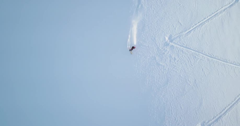Skier descending a white slope