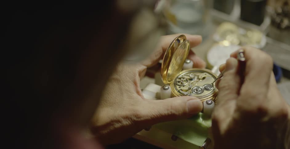 A man is repairing a watch on the workbench