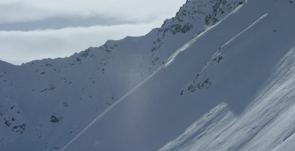 A person skis down a big mountain ridge