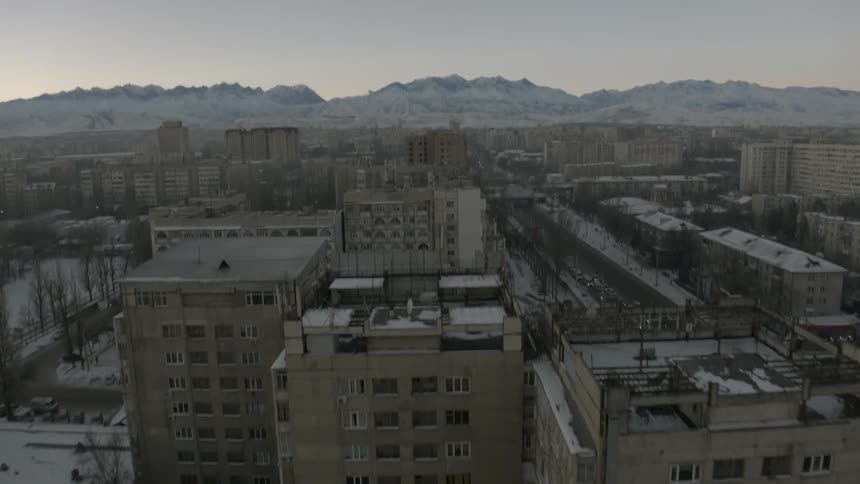 Snow covered buildings are viewed from above