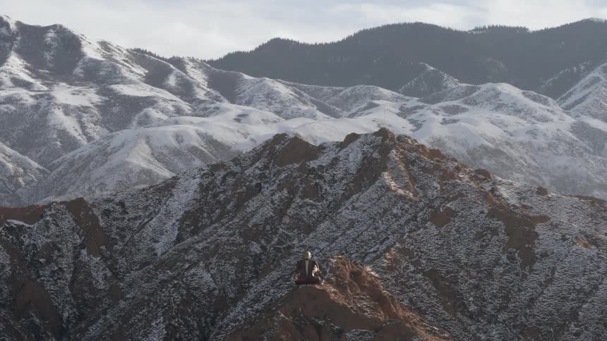 A statue sits on a mountain peak