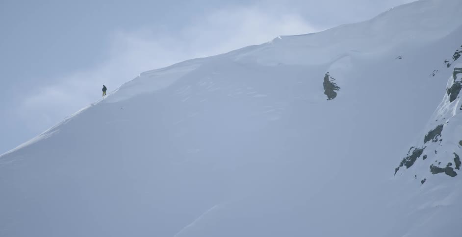 A person standing on top of a snow covered mountain