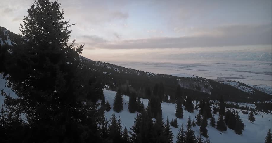 The sun sets over snowy mountains