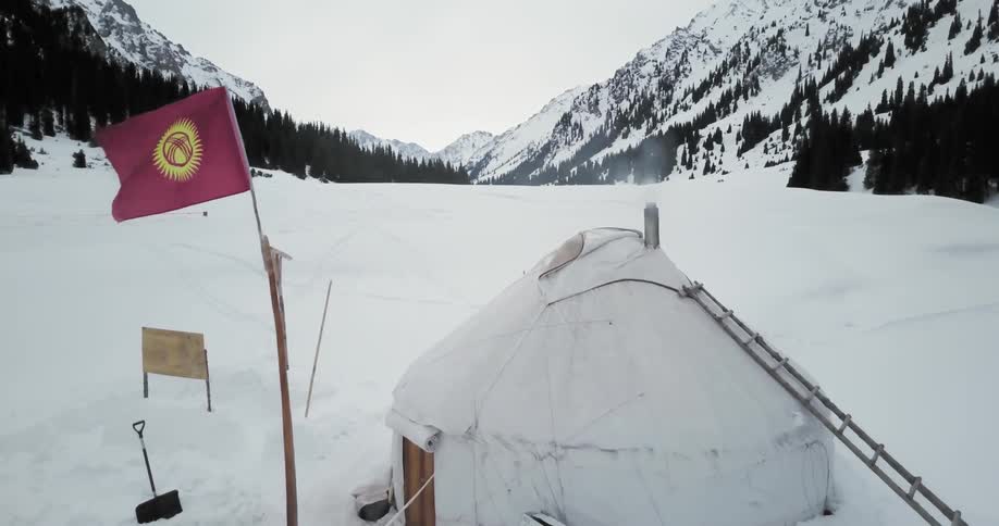 Smoke rises from a heated ice fishing shelter in the snow
