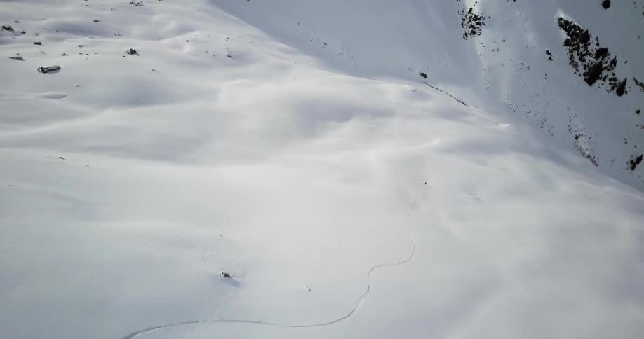 A skier glides down a snowy mountainside