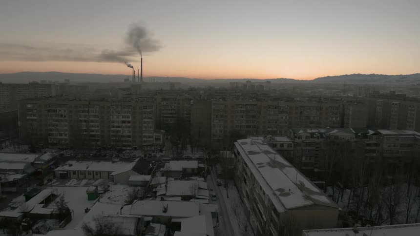 Snow covers a city at sunset