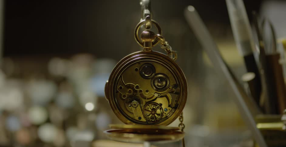 A pocket watch is open and the gears are spinning