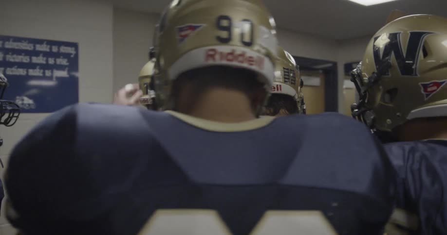 Football players in uniform leave the locker room