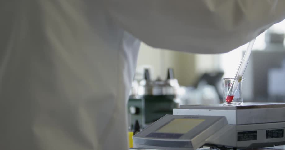 A scientist pipettes liquid in a laboratory