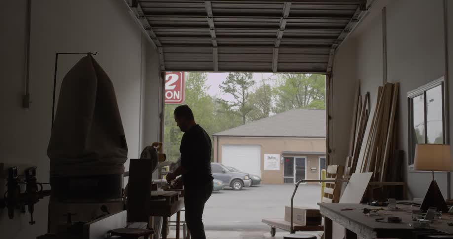 Someone is using a table saw to cut something in a garage