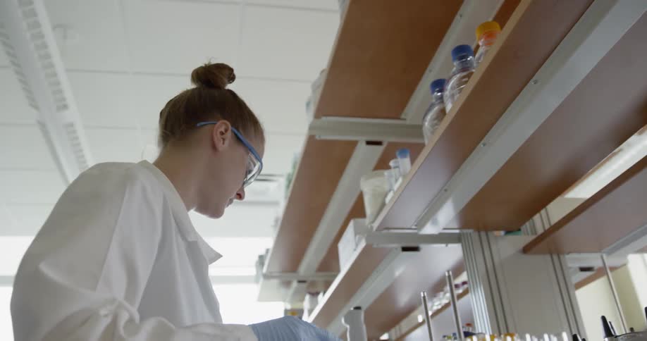 A scientist is looking at vials