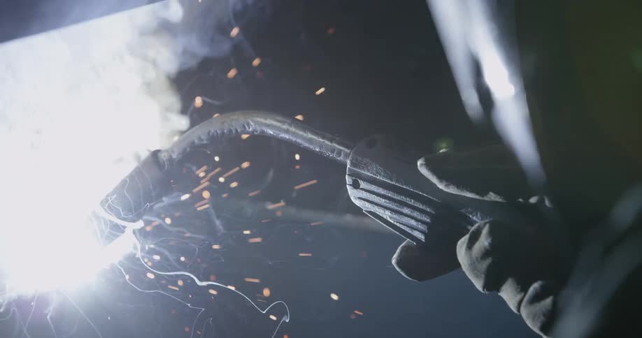 A man welds steel with a welding torch