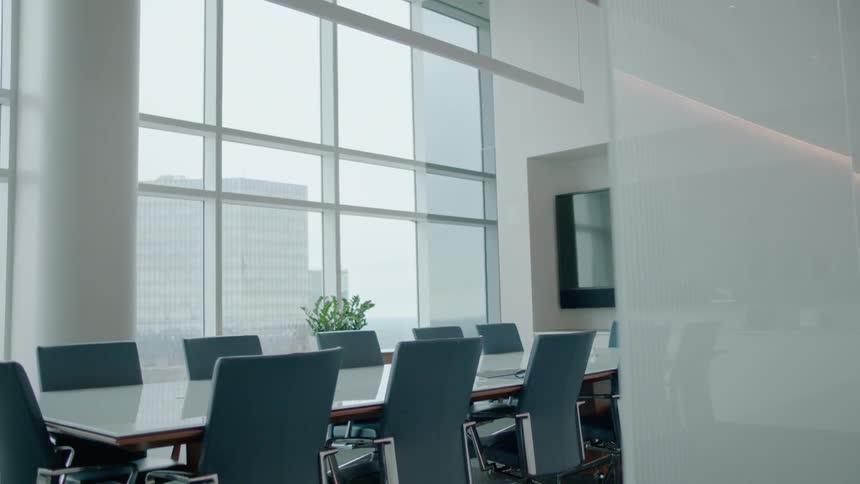 A conference table sits empty in a boardroom during the day