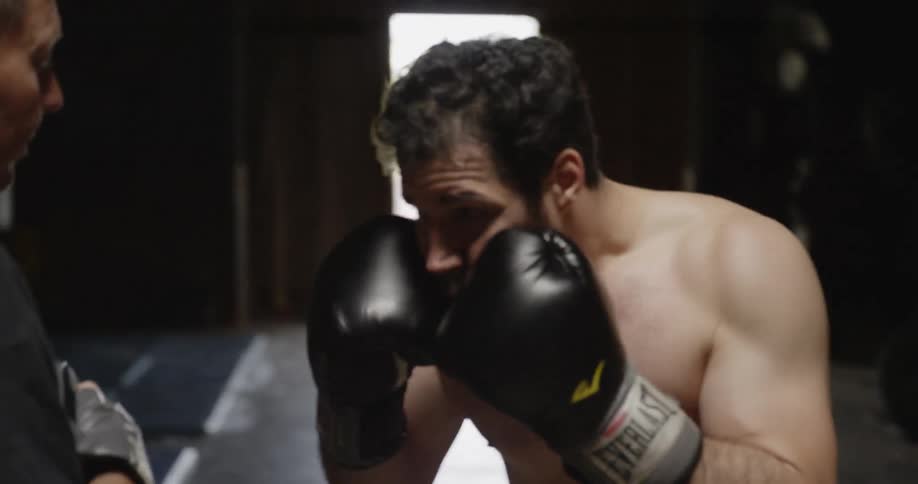 A man is sparring with his boxing coach
