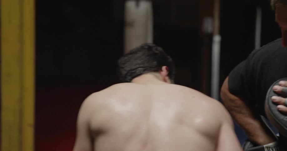 A boxer and a trainer are sparring