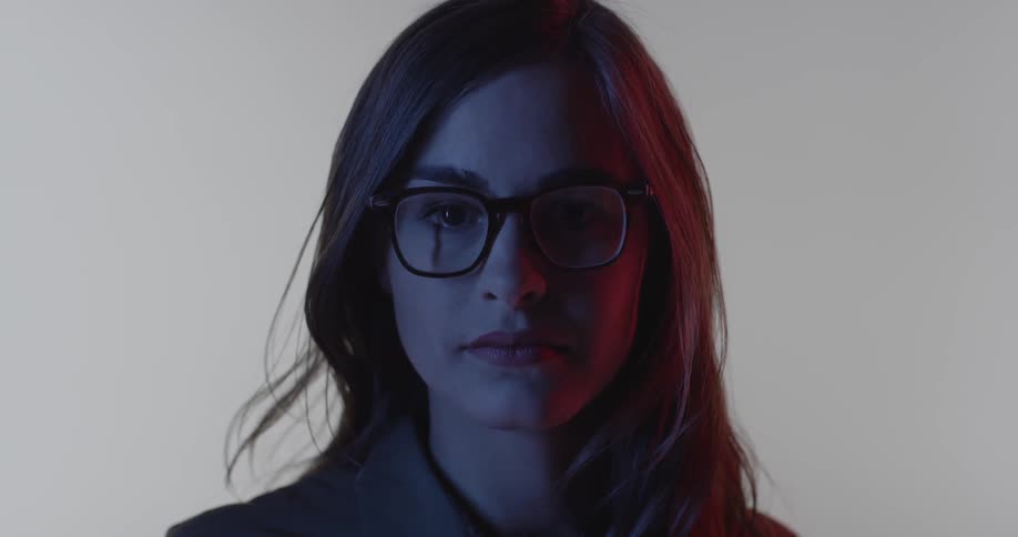 A woman is wearing glasses as she stares straight ahead