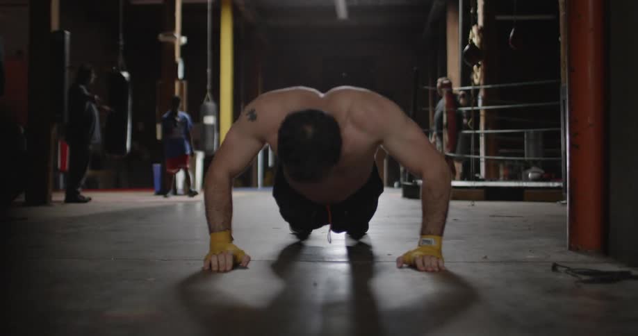 Man in gym drops and does push ups