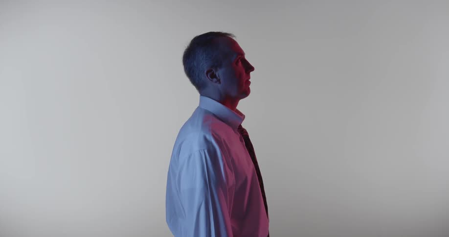 Someone is standing in the middle of a white room looking to their side
