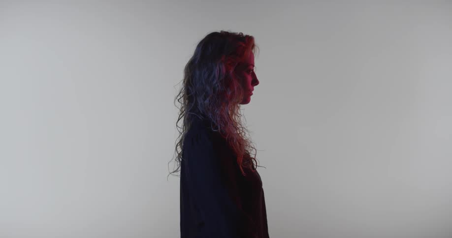 A woman with long hair stands in profile