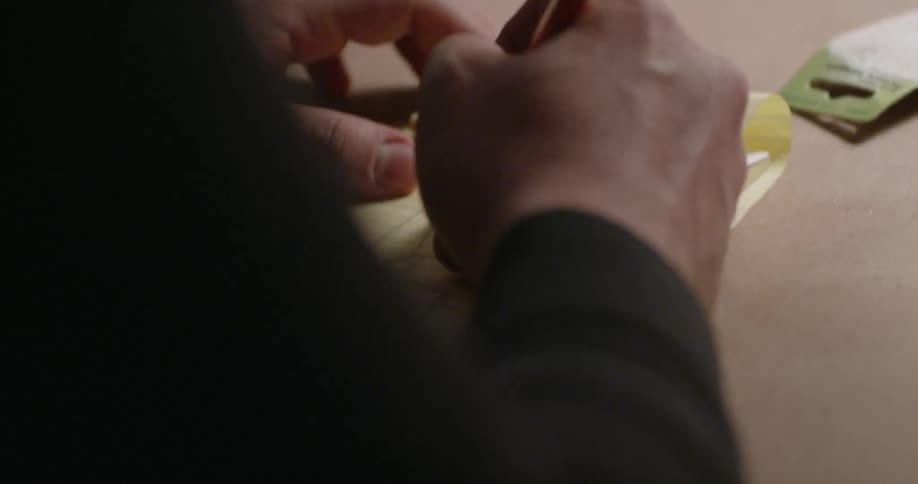 Someone is using a pencil and a small notepad to sketch