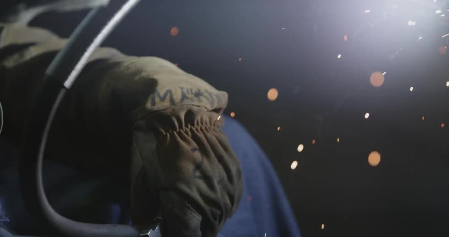 Sparks fly around a welder