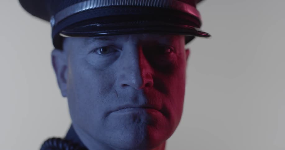 A police officer is blinking as he looks forward