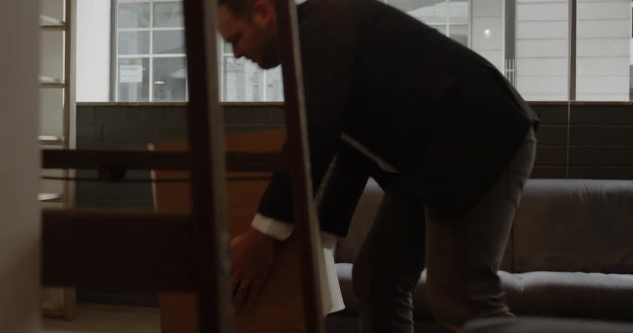 A man is carrying a box into an office during the day