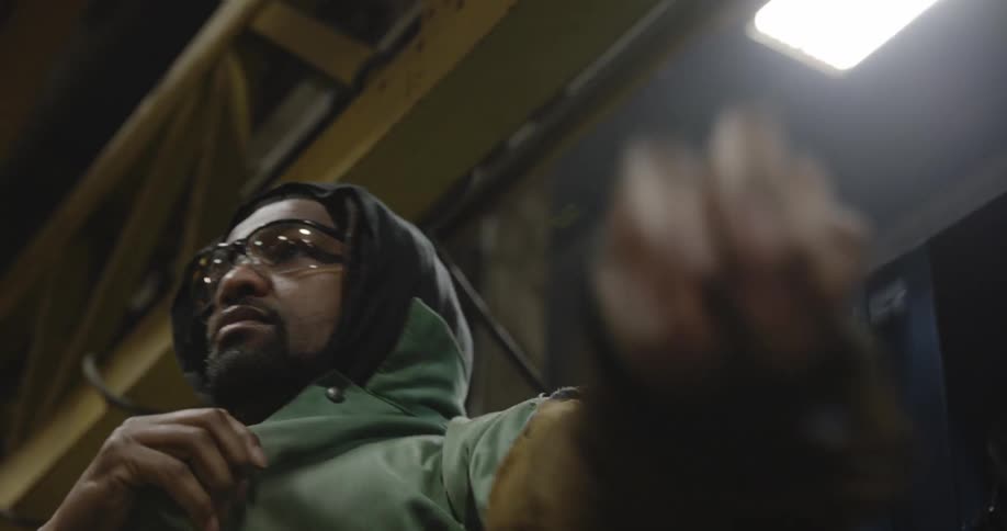 A man is wearing a protective jacket in a factory