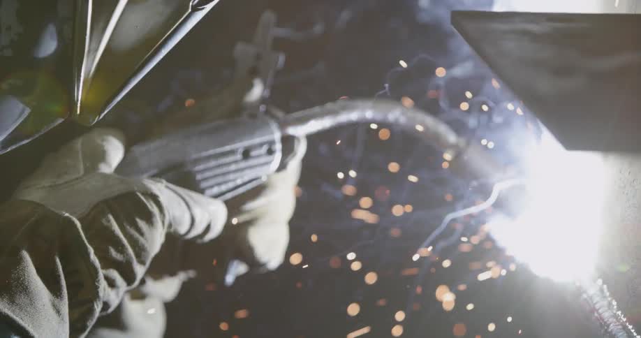 A person is using a welder torch on a piece of metal