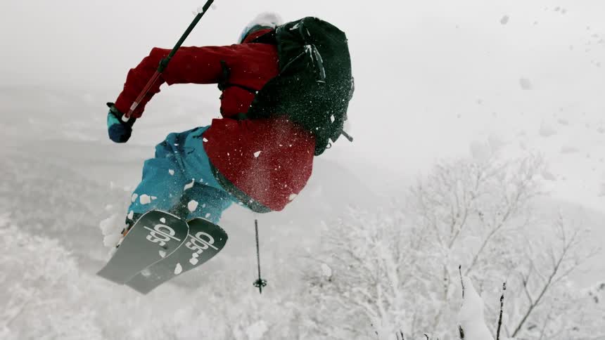 A skier is jumping off a ridge in a remote area on a winter's day