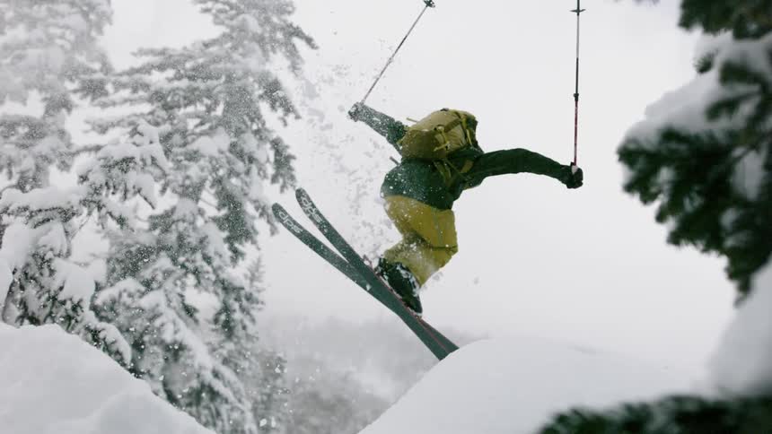 A skier flies through the air into powder snow