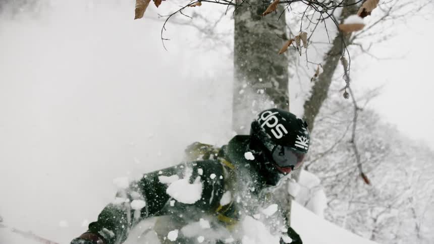 A skiers glides down a snowy mountainside