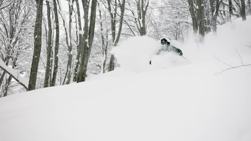 A man skis down through deep snow