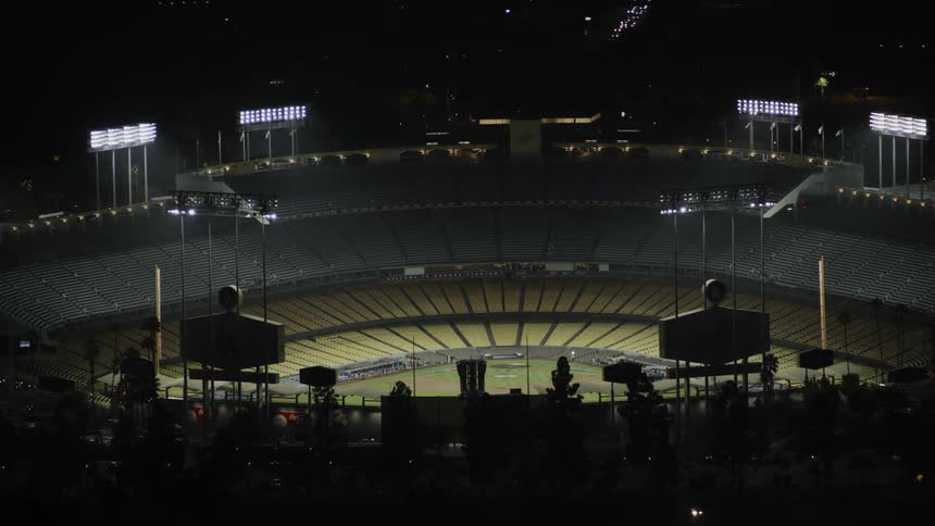 Flood lights illuminate an empty baseball field at night