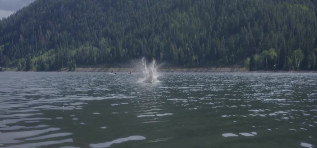 A man jumps into a lake from high above