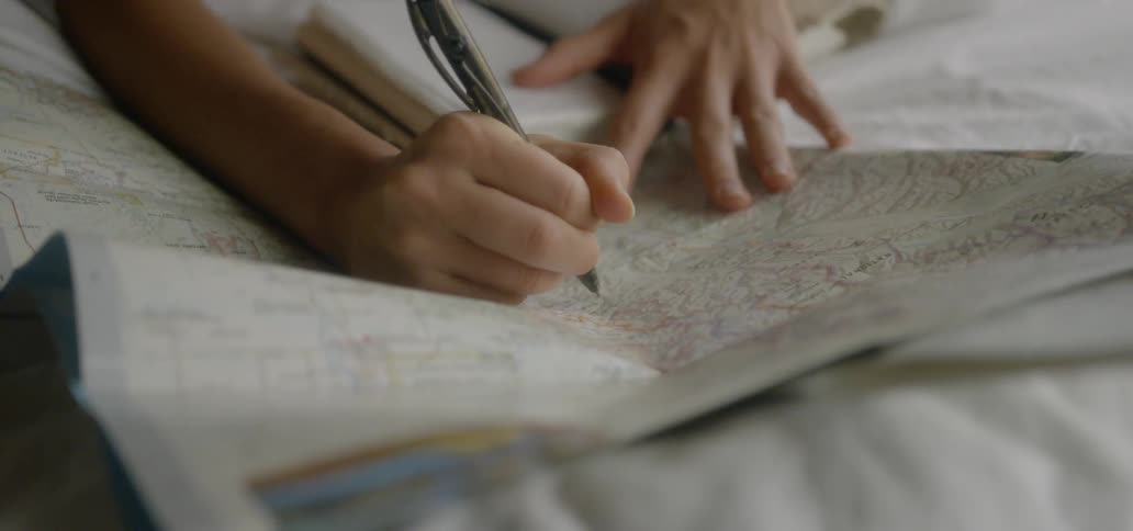 Person circling a place on a map with a pen