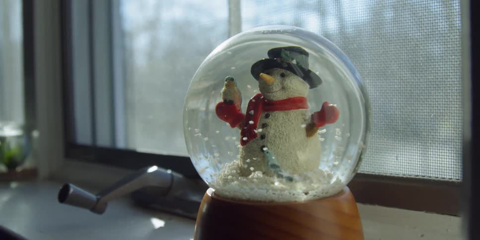 A snow globe sits on a windowsill