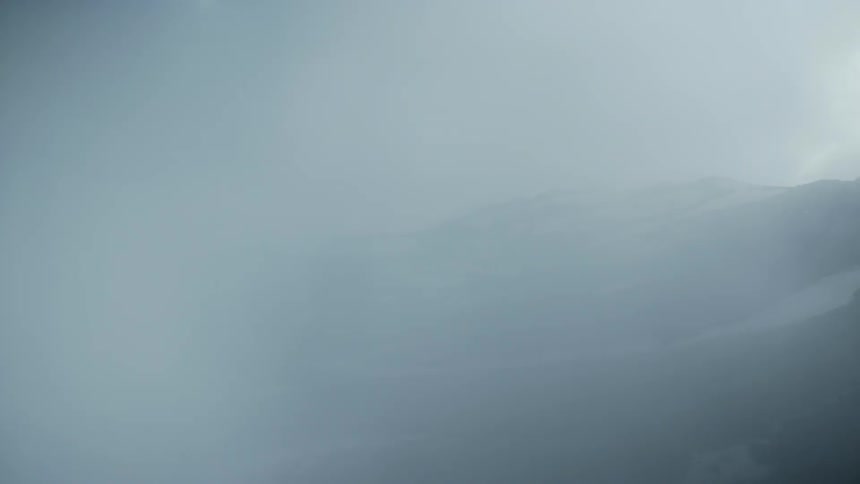 Fog rolls over hills on a cloudy day