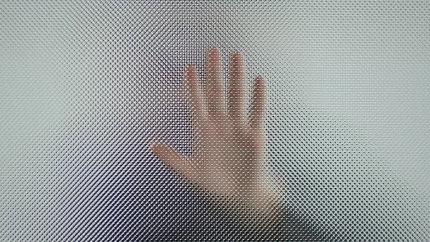 A woman puts her hand on glass