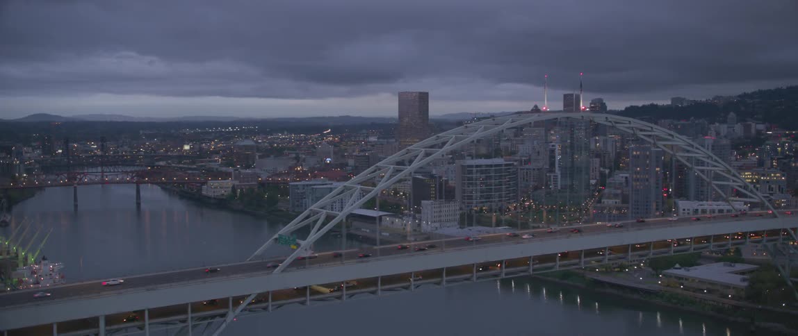 Bridge spanning a large river in a big town on a cloudy evening