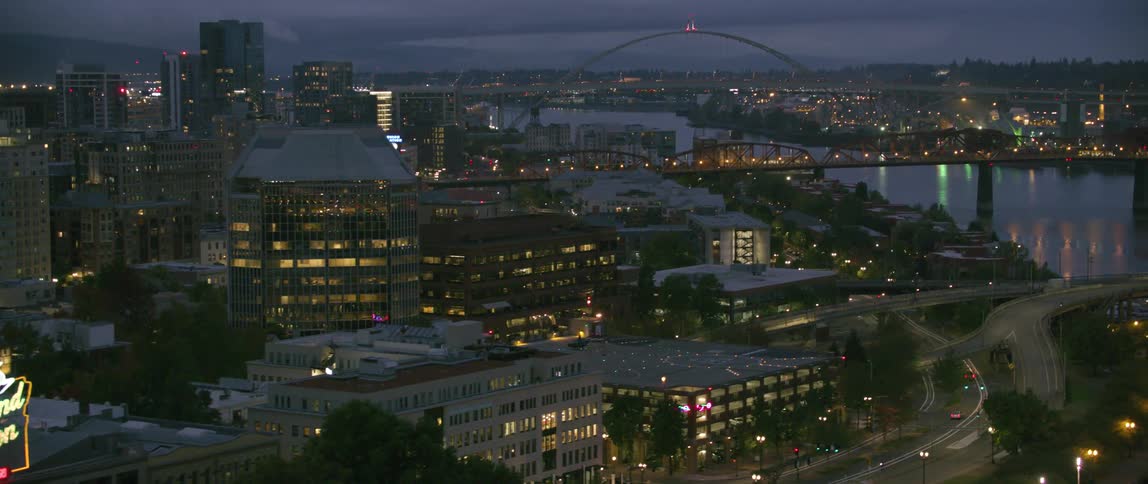 Lights illuminate a city near the river at night