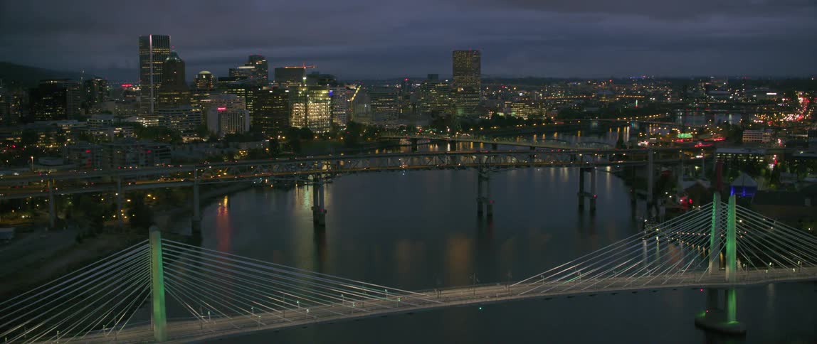 Bridges spanning a river in a big city on a cloudy evening