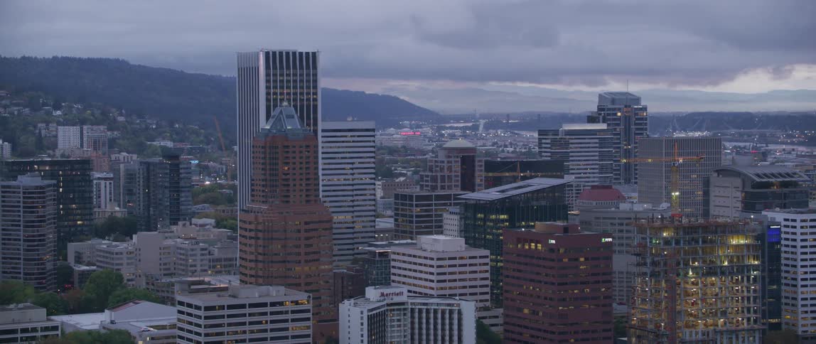 Skyscraper windows reflect the city lights on a cloudy day