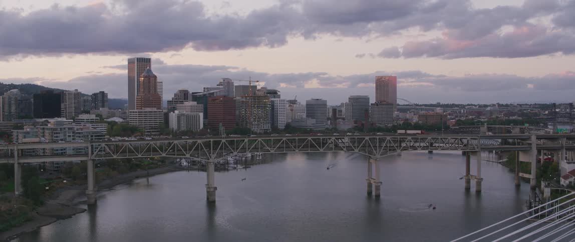 Bridges span a city river at sunrise